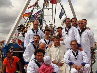 i marinai di Santo Spirito e don Luciano Cassano, parroco di Catino, con la statua di san Nicola al termine della processione 
